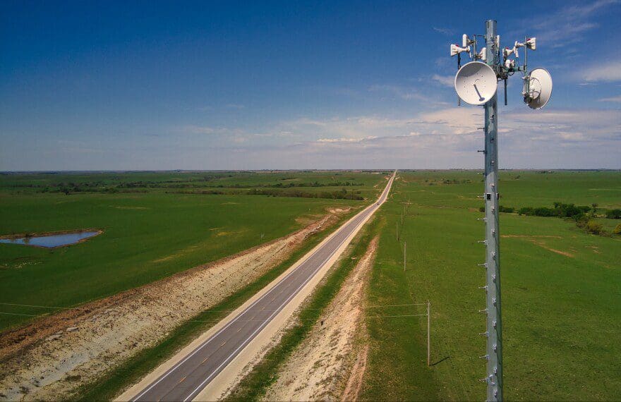 A wireless internet tower next to a road